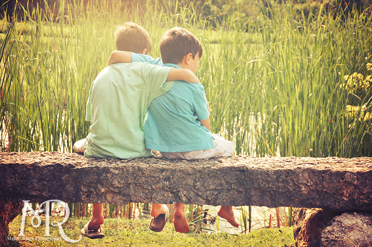 Brothers embracing on a stone bench overlooking a pond // Leroy Oaks // by Mandy Ringe Photography