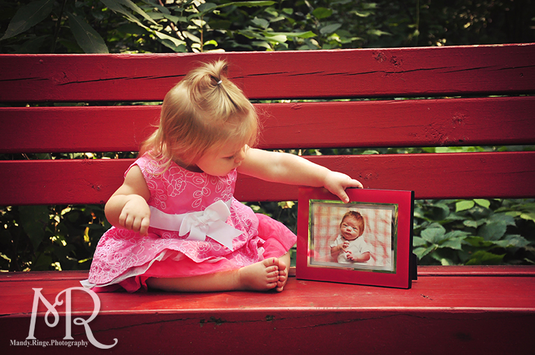 First birthday photos. Baby girl sitting with her newborn photo. // Delnor Woods Park // by Mandy Ringe Photography
