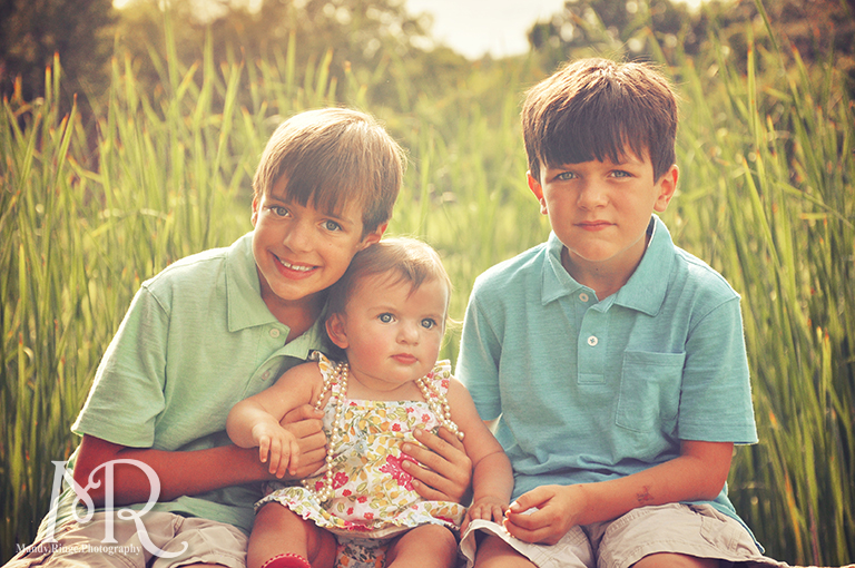 Siblings sitting on a stone bench overlooking a pond // Leroy Oaks // by Mandy Ringe Photography