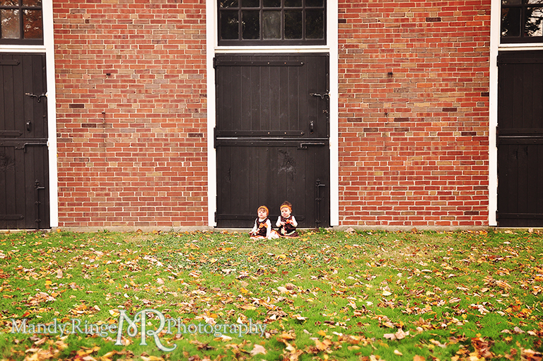 Fall portraits of 9 month old twins wearing Thanksgiving dresses // Sitting in front of brick stables // St. James Farm - Wheaton, IL // by Mandy Ringe Photography