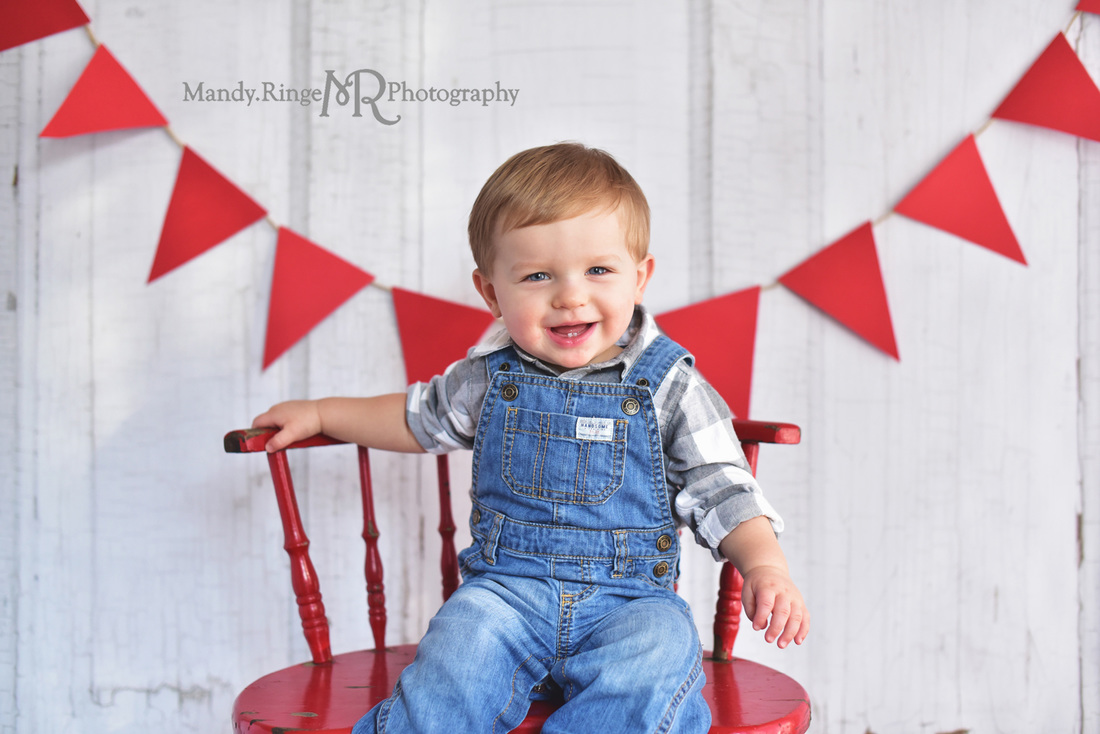 Boy's first birthday portraits // Red, gray, blue, overalls, shabby red chair, pennant banner, vintage inspired // Traveling studio session at client's home - South Elgin, IL // by Mandy Ringe Photography
