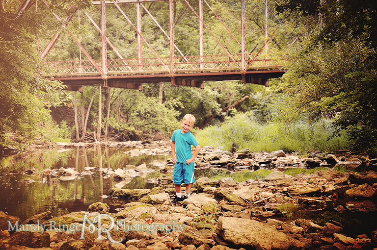 Young boy standing in a creek bed with a bridge in the background // Child Photography // Eaton, OH // by Mandy Ringe Photography