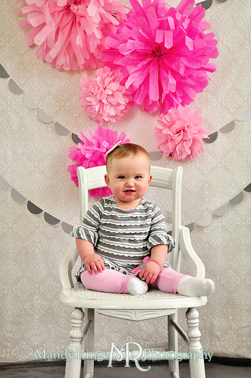Baby girl's first birthday photo shoot. Pink tissue paper poms, gray paint chip garland // Pink, gray and white birthday // by Mandy Ringe Photography