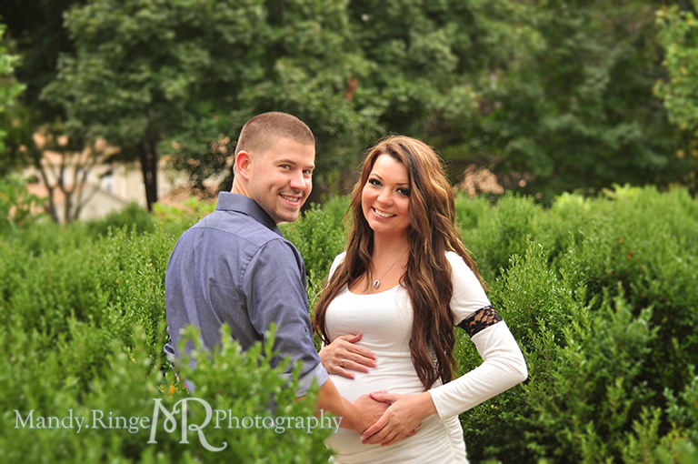 Man and pregnant woman facing each other with the man holding her belly // Maternity portraits // Hurley Gardens - Wheaton, IL // by Mandy Ringe Photography