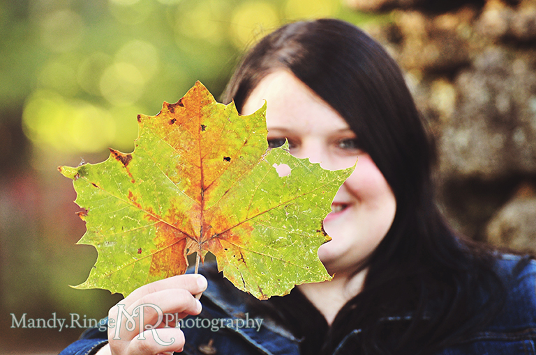 Teen girl holding up an autumn leaf // Senior Photos // Fabyan Forest Preserve - Batavia, IL // by Mandy Ringe Photography