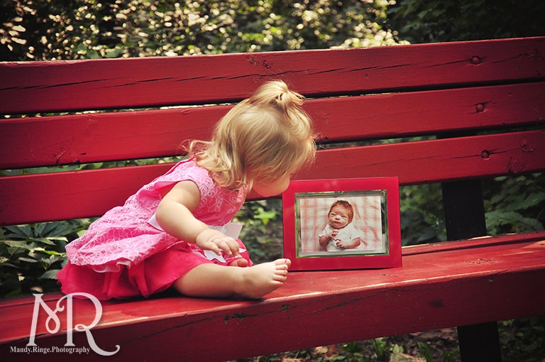First birthday photos. Baby girl sitting with her newborn photo. // Delnor Woods Park // by Mandy Ringe Photography