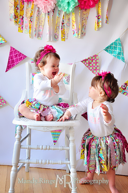 Twin girl's first birthday portraits // White chair, fabric pennants, rag banner, rag skirt, pink, teal, fuchsia, yellow, tissue paper pom poms // by Mandy Ringe Photography