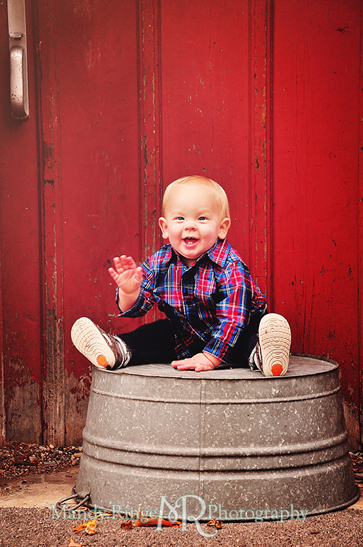 1 year old boy sitting on a wash tub in front of a red barn // First birthday portraits // Leroy Oaks - St Charles, IL // by Mandy Ringe Photography
