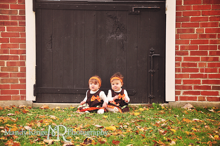 Fall portraits of 9 month old twins wearing Thanksgiving dresses // Sitting in front of brick stables // St. James Farm - Wheaton, IL // by Mandy Ringe Photography