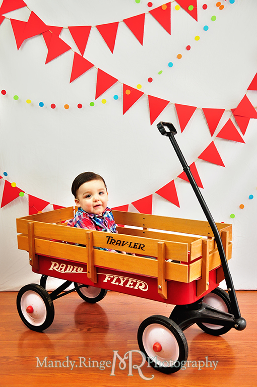 Boy's first birthday // Sitting in a Radio Flyer wagon // Red pennant banners, multicolor dot garland, wagon // by Mandy Ringe Photography