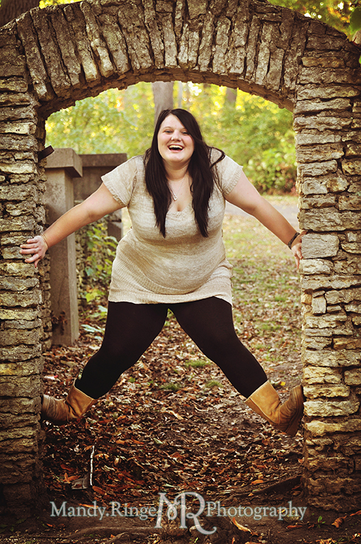 Teen girl being silly, climbing the inside of a stone arch // Senior Photos // Fabyan Forest Preserve - Batavia, IL // by Mandy Ringe Photography
