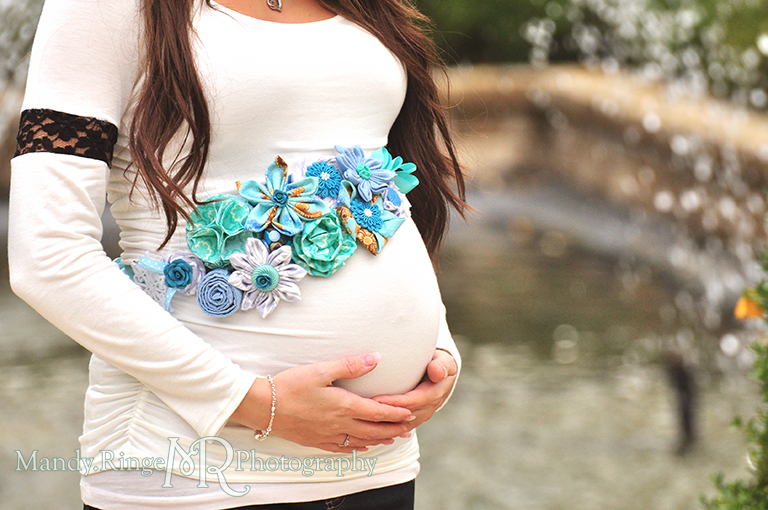 Belly shot of a pregnant woman holding her belly and wearing a handmade blue maternity sash // Maternity portraits // Hurley Gardens - Wheaton, IL // by Mandy Ringe Photography
