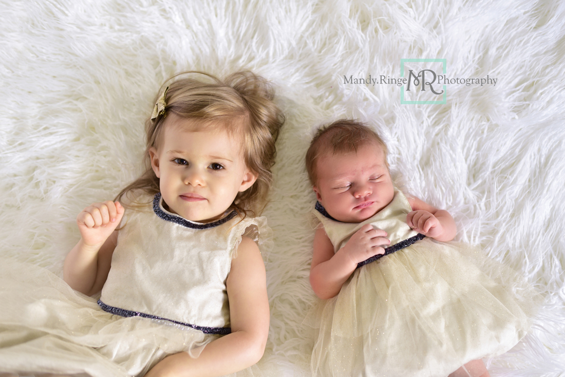 Newborn girl portraits // Sibling portraits, laying on white fur, matching dresses, ivory and navy // Client's home - St Charles, IL // Mandy Ringe Photography